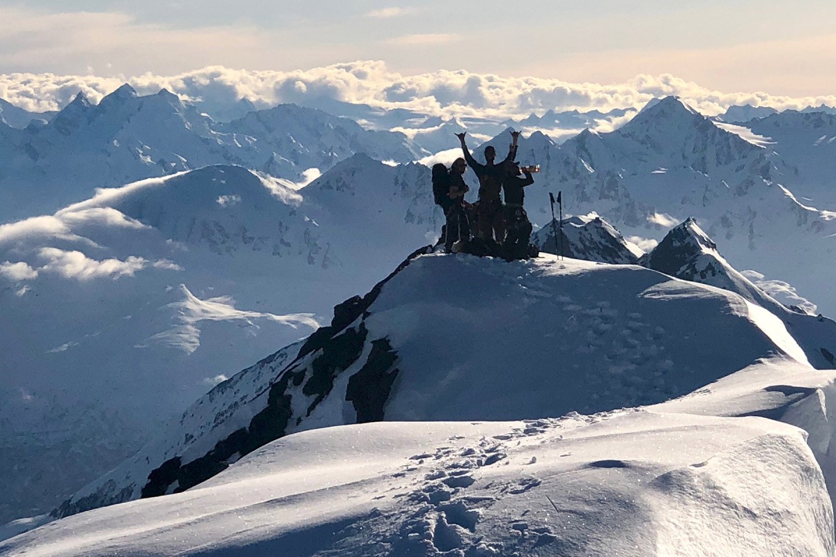 A group celebrate after reaching the top about to skiing down in the Turkey Zone, in the Chugach.